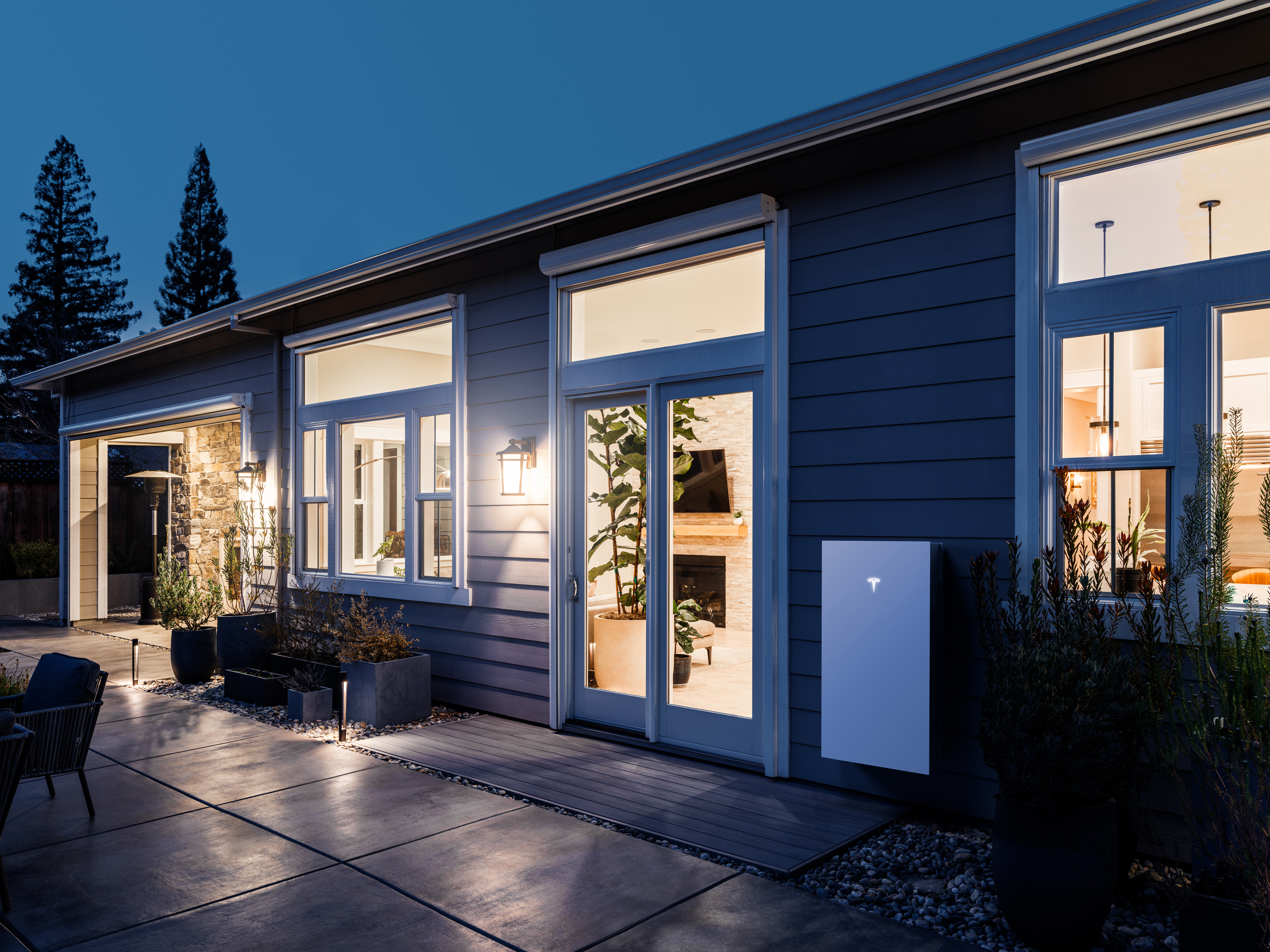 Tesla Powerwall on the side of a home at night